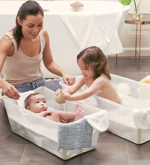 Madre bañando a sus hijas en bañera Plagable Flex Bath